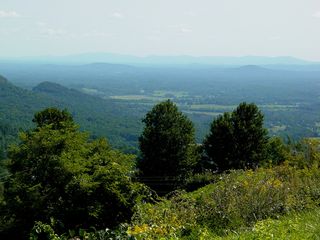 Afton Mountain is part of the Blue Ridge Mountains, with traffic crossing Rockfish Gap via Interstate 64 (top left), and US 250 (lower left), with views of Waynesboro (top right) and Nelson and Albemarle Counties (lower right).