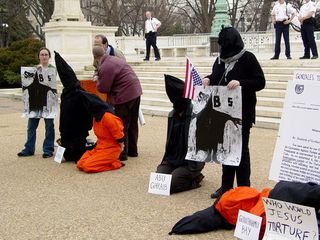 The main theme of the demonstration was to show victims of torture, with Guantanamo Bay and Abu Ghraib featured prominently. Participants held their hands behind their back as if handcuffed or otherwise restrained.