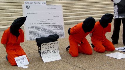 The main theme of the demonstration was to show victims of torture, with Guantanamo Bay and Abu Ghraib featured prominently. Participants held their hands behind their back as if handcuffed or otherwise restrained.