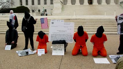 The main theme of the demonstration was to show victims of torture, with Guantanamo Bay and Abu Ghraib featured prominently. Participants held their hands behind their back as if handcuffed or otherwise restrained.