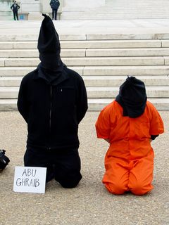 Some participants had signs near them, such as "Abu Ghraib" and "Guantanamo Bay".