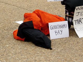 One participant laid on their side for a time, which made for quite a dramatic appearance, with the "Guantanamo Bay" sign prominently displayed.