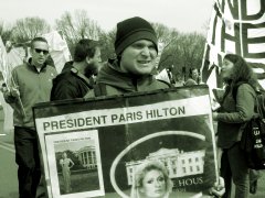 A person holds a sign depicting Paris Hilton as president