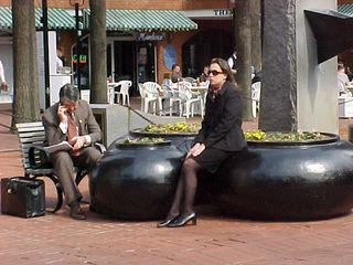 Beside the fountain, businesspeople wait, or conduct business by phone.