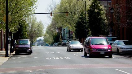 The streets in downtown Lynchburg, particularly Main Street, shown here, are mostly one-way, and feature brick crosswalks and intersections. Additionally, the streets are lined with trees, providing shade for the sidewalks.