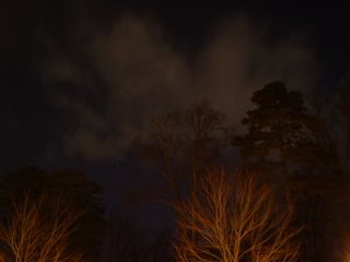 The orange-yellow glow of the security lighting also illuminates low lying clouds, with them reflecting the light back onto the ground.