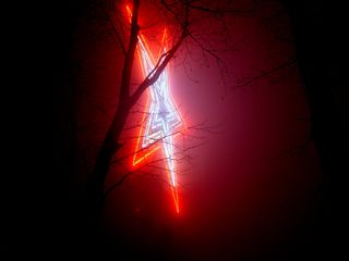 As viewed from the side and taken at longer exposures, the fog, along with the glow of the outer red neon, seems to create the illusion of the outermost ring being a ring of flame.