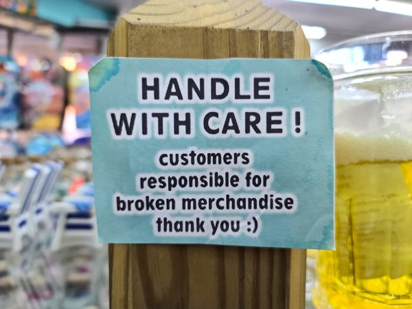 Sign at ILoveVA, a gift shop in Virginia Beach, Virginia, warning customers to handle the products with care, because they are responsible for broken merchandise.