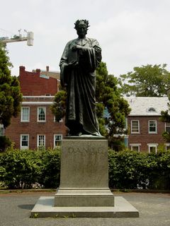A statue of Dante Alighieri stands dressed in classical attire on the east side of the park.