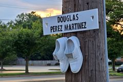 White "ghost shoes" attached to a utility pole in memory of Douglas Perez Martinez in front of the Liberty gas station in Gaithersburg, Maryland.