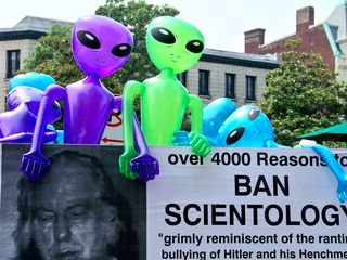A small farm of inflatable aliens rings the edge of Arnie Lerma's truck, topping off two large signs critical of the Church of Scientology.