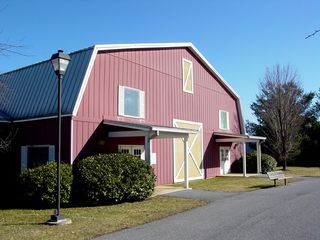 Building 3 was one of the more noteworthy buildings in the Outlet Village, due to its barn-like appearance and adjacent silo. This building originally was home to a Gitano outlet, and later was an early home for the Artisans Center of Virginia. At the time of photography, the left side of the building housed offices for One Child At A Time, which provided academic assistance to high-school students.