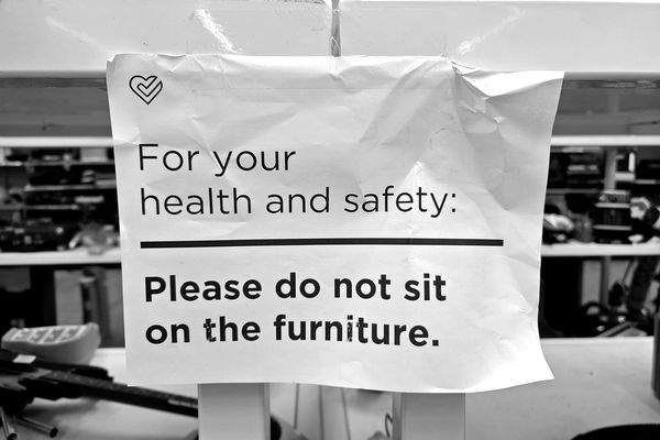 Sign on a shelf at the Unique Thrift Store in Hillandale, Maryland advising customers not to sit on the furniture, ostensibly to prevent the spread of COVID-19.
