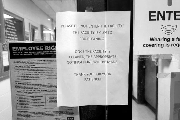 Sign on the main entrance to a building advising people that the facility is closed for a COVID-related cleaning.
