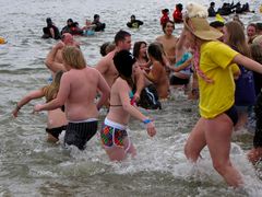 The first plunge is underway, as people run into the ice-cold waters of the Chesapeake Bay.