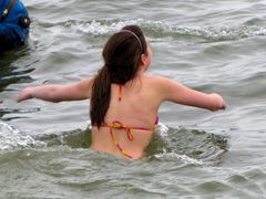 A woman enters the water.