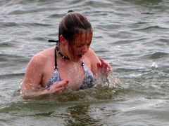 A woman comes out of the water after submerging.