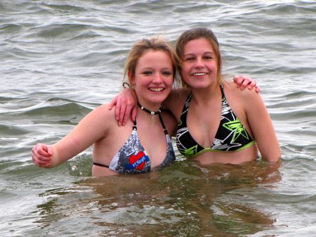 Two young women pose for the camera after going waist-deep into the water.