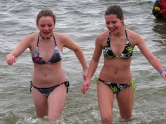 Two young women are all smiles as they emerge from the water.
