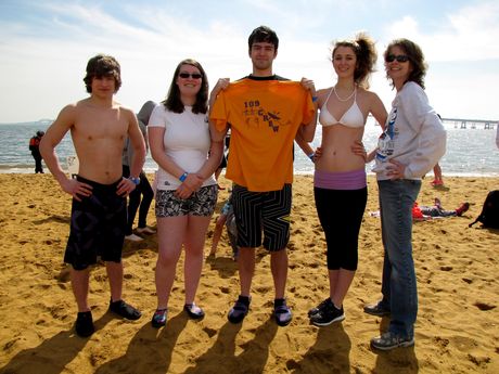 A group of five people poses for the camera at the beginning of the event. The man in the middle is holding a t-shirt reading "109 Crew".