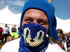 A man shows off his Sonic the Hedgehog costume, consisting of a Sonic-style hat, and a beaded face mask featuring Sonic's face.