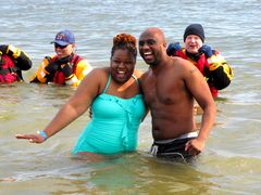 A couple poses for photos while standing in the water during the third and final plunge of the day.