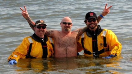 A man poses for a photo with the support divers.