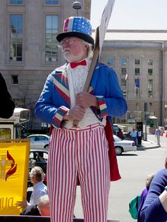 Following this "money" theme, we found protesters carrying American flags altered to show corporate logos instead of stars, a man dressed up as Uncle Sam (the hat also carried this corporate-logo theme), and one man went all out and wore a suit and a George W. Bush mask, holding a modified $1 bill similar to the large sign. His companion had a number of news logos all over her person.
