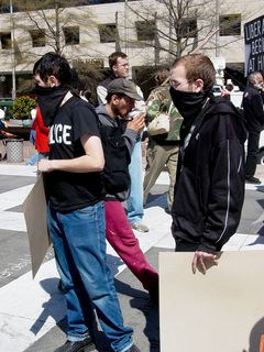 Just up from the chalk writer, I ran into two masked protesters using black bloc techniques. These two gentlemen were milling about like everyone else. Those demonstrators in black bloc eventually gathered at the west end of the plaza.