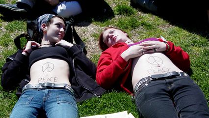 Creativity! These two women used their own natural canvas to draw peace signs on themselves.