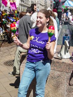 This woman wears "PEACE" prominently, while rattling a set of maracas.