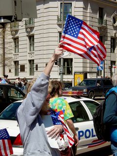 On the outer perimeter, a woman hands out American flags.