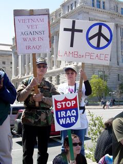 A Vietnam veteran protests the Iraq war, along with a companion. Also note the "Stop Iraq War" sign being held by the protester in front of them.