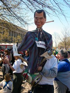 Near the west end of Freedom Plaza, this person holds an effigy of George Bush and beats a drum.