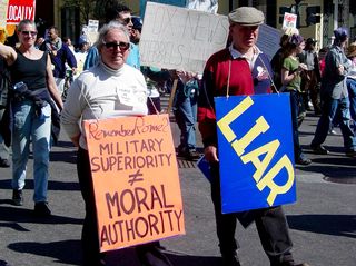 After the Clinton-era sex scandals, the notion came up of the president's need to be a moral leader as well as a political leader. This protester simply reminds us of Rome, and how military superiority does not make moral authority, while her companion simply carries a sign stating "LIAR".