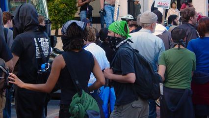 Early on, the masked black bloc protesters passed through the intersection...