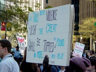 This protester's sign shows the text of Revelation 18:21 from the New Testament. 