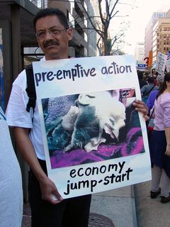 Among the more disturbing images presented, this protester holds a photograph of an innocent Iraqi citizen injured after attacks.