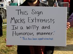 Sign reading, "This sign mocks extremists in a witty and humorous manner," while also poking fun at misspelled protest signs.