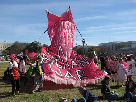 Members of Code Pink raise a large pink slip behind the rally stage, calling for an end to the war in Afghanistan.