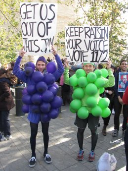 Two men dress as grapes, with plays on jams and raisins on their signs.