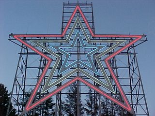 The lights are on, and the sky is blue. I love the way the star sits against the structure and the sky.