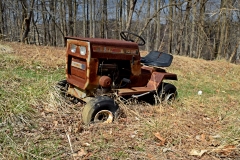 Rusted Sears Craftsman LT1036 lawnmower, in the yard north of the house