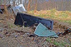 Fisher Studio-Standard television, discarded and broken on the ground in front of the house