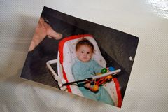 Photograph of a baby in a seat, taken in the family room