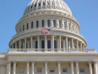 The flag of the United States flies in front of the dome.