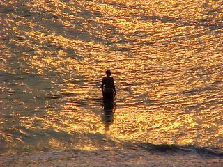 And as the sun gets up, a man plays in the surf.