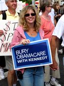 A woman holds a sign saying, "Bury Obamacare with Kennedy".