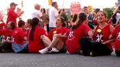 In the picket's final stage, a row of people sat in the street with locked arms as part of a civil disobedience action.