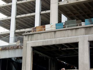 Looking inside, elevator shaft openings around the building's concrete core have been boarded up, and the floor slabs are completely bare.